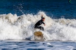 a man riding a wave on top of a surfboard