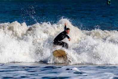 a man riding a wave on top of a surfboard