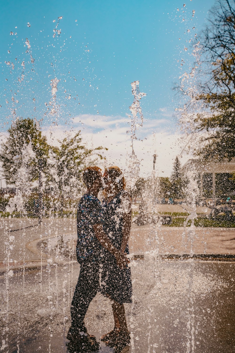 two people standing in front of a water fountain