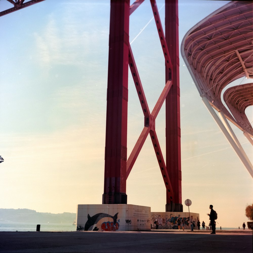 a tall red bridge with a sky background