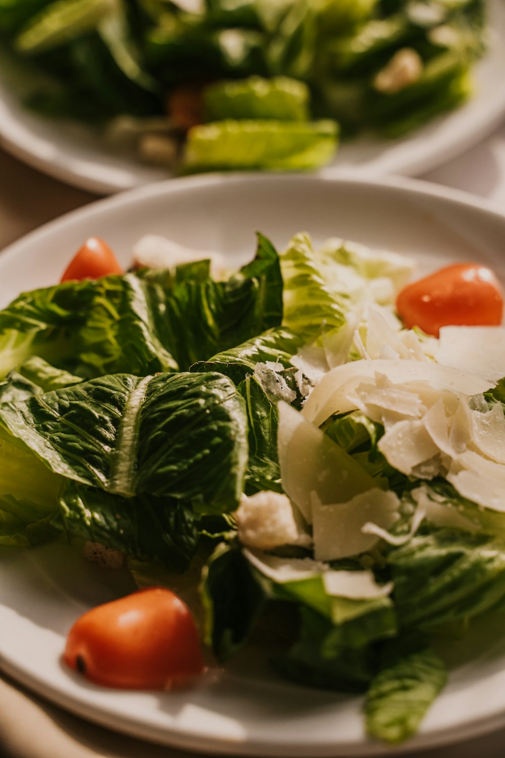 a white plate topped with lettuce and tomatoes