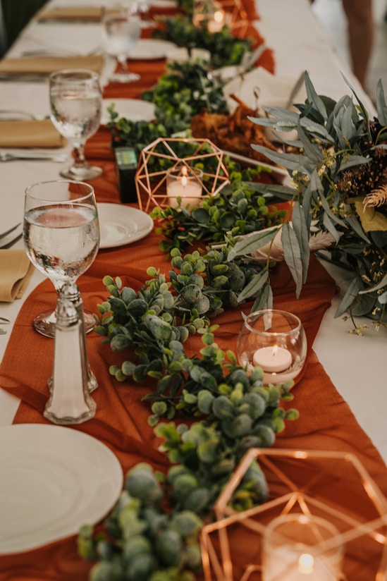 Elegant table setting with warm beige and terracotta tones, showcasing a beautifully arranged catering spread.