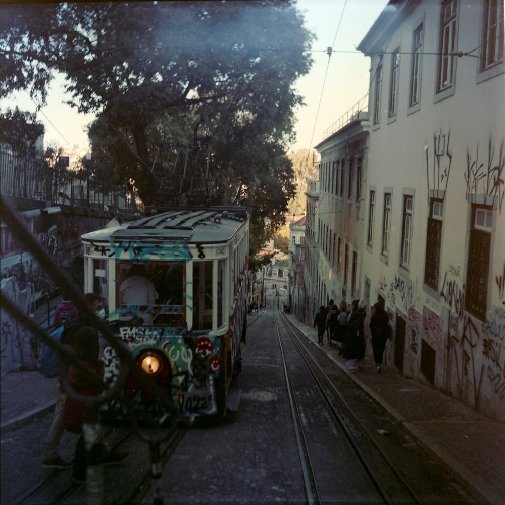 a trolley car with graffiti on the side of a street