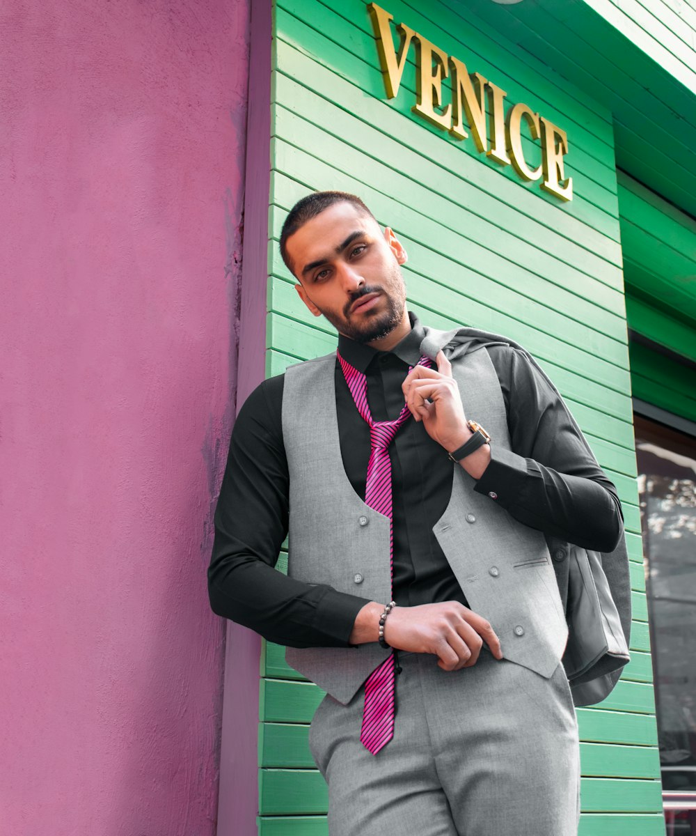 a man wearing a vest and a pink tie