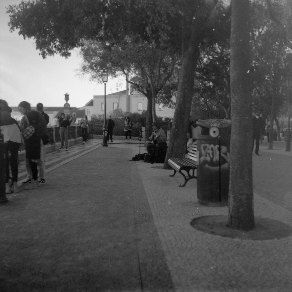 Una foto in bianco e nero di persone su un marciapiede