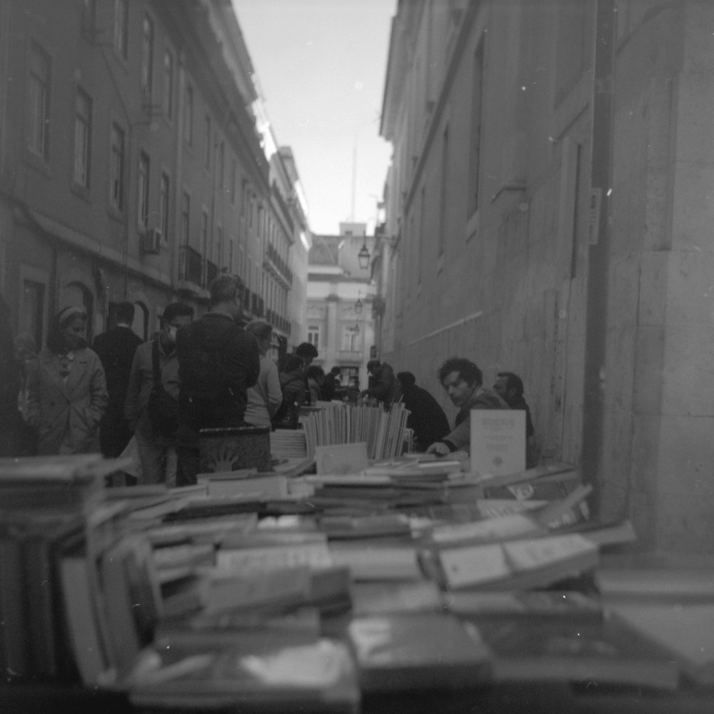 a group of people standing around a table filled with books