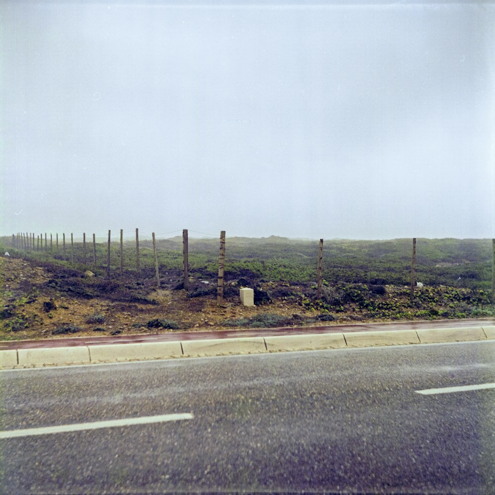 a road that has a fence on the side of it