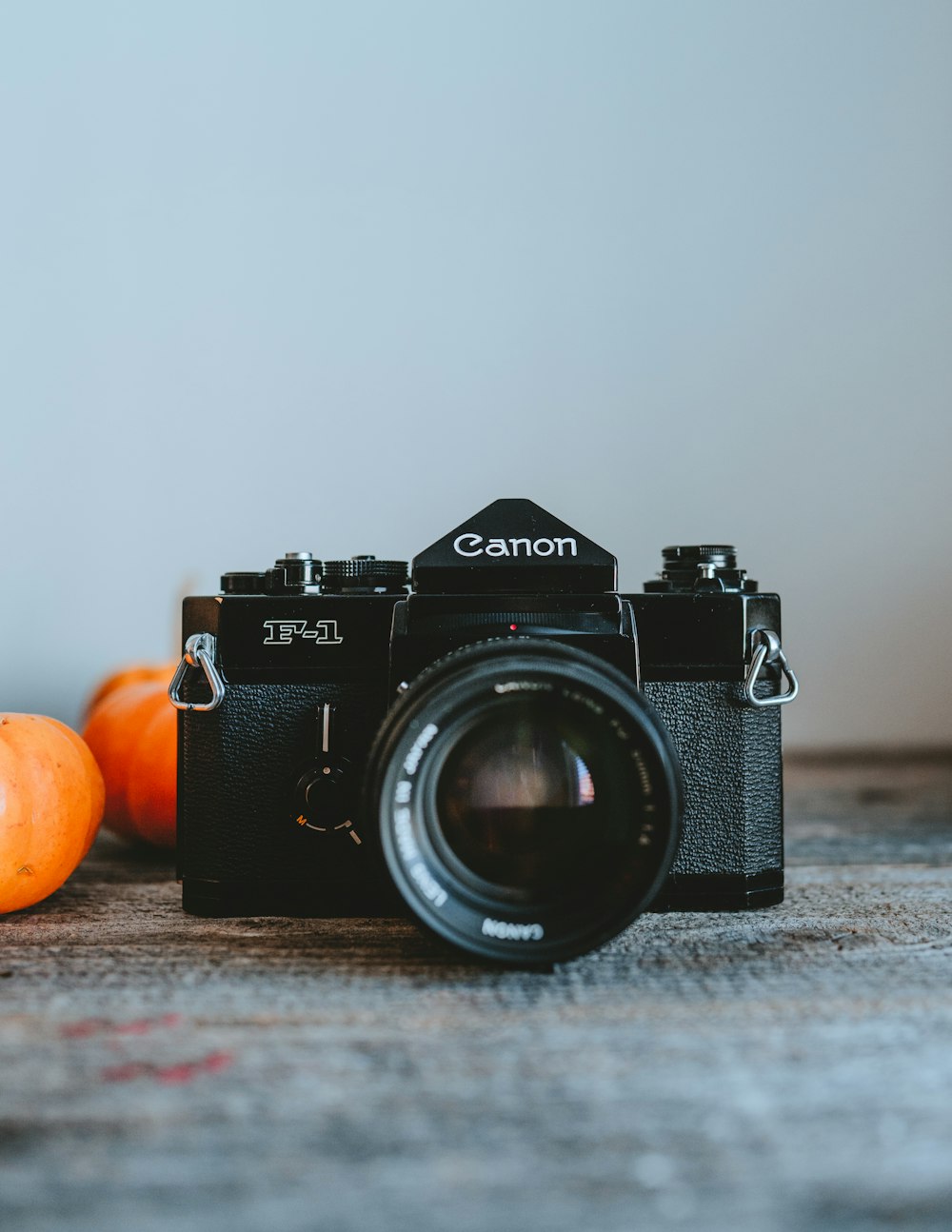 a camera and some oranges on a table