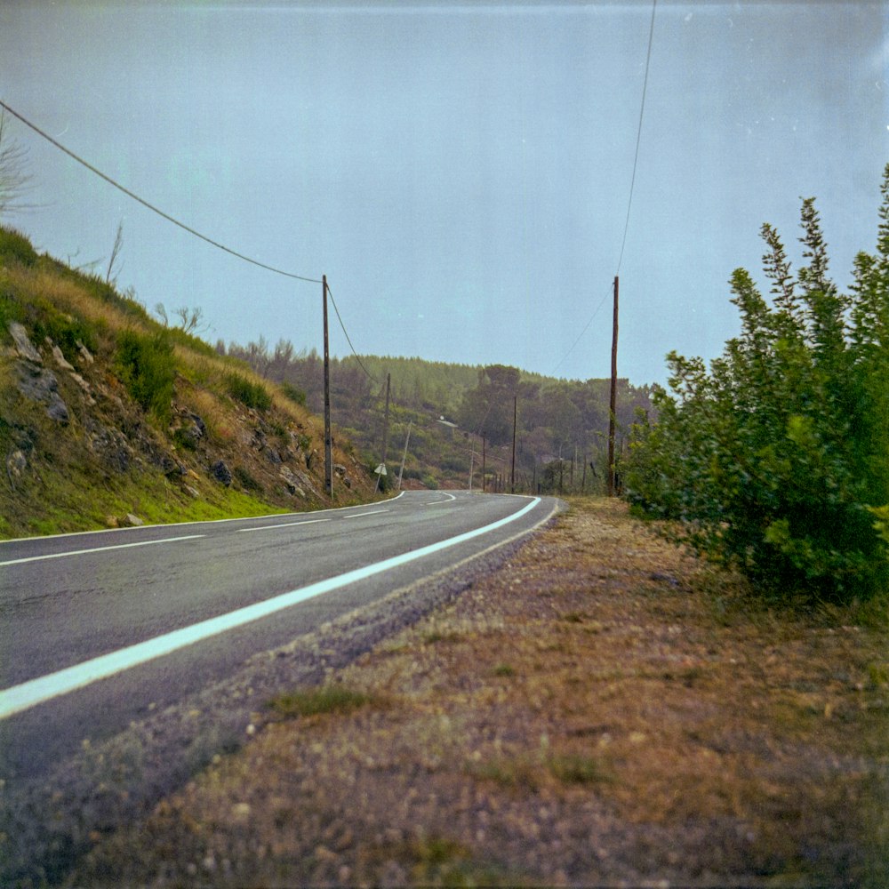 an empty road on the side of a hill
