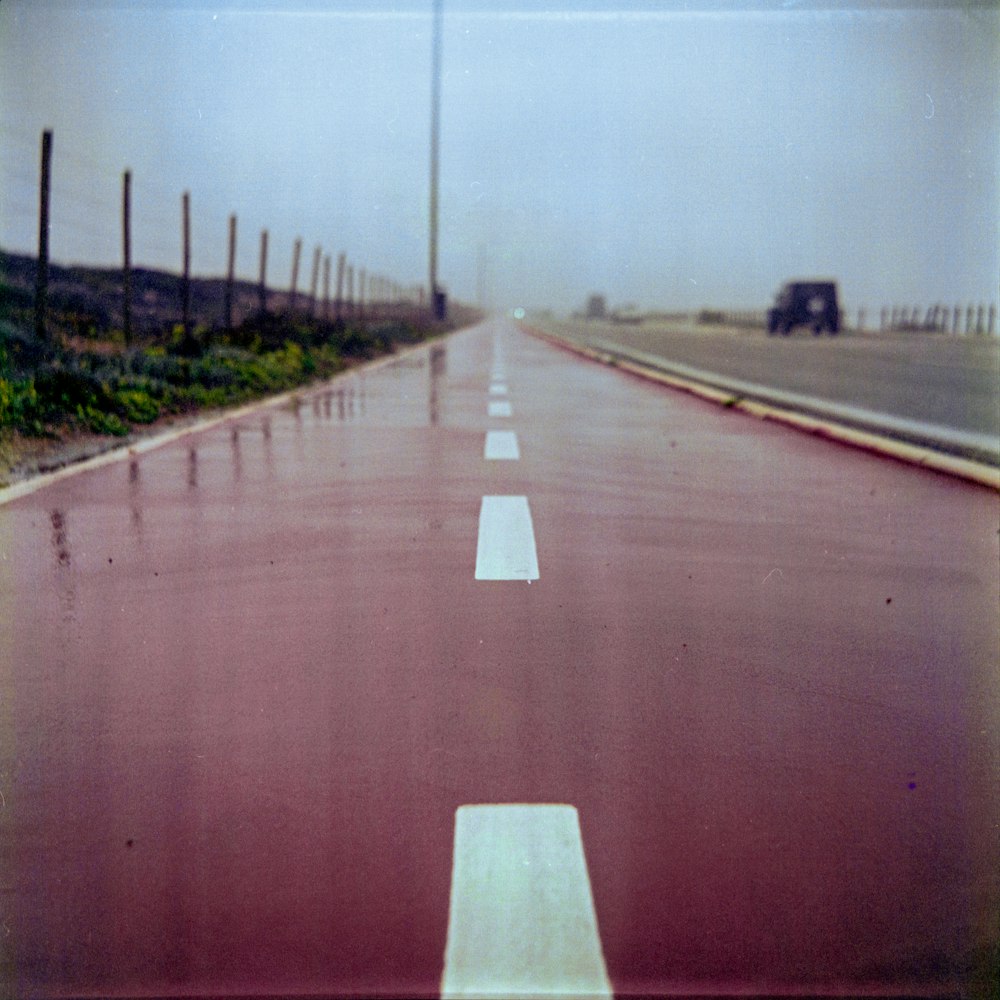 an empty road with a truck on the side of it