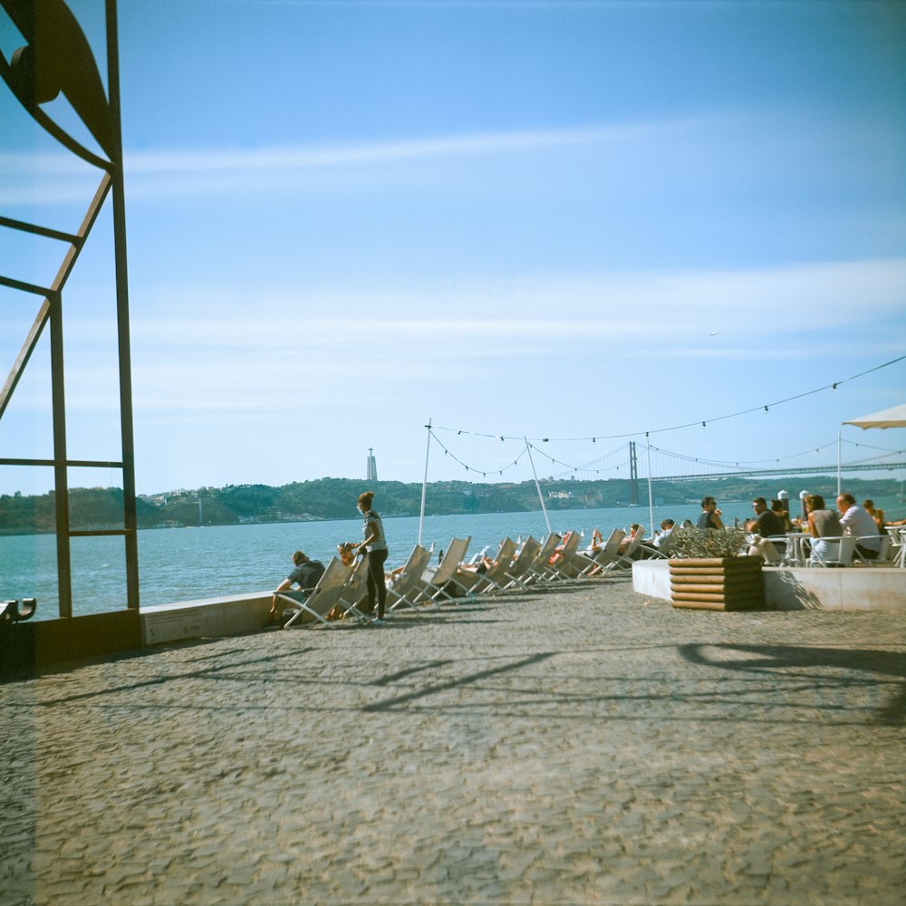 a group of people sitting on top of a sandy beach