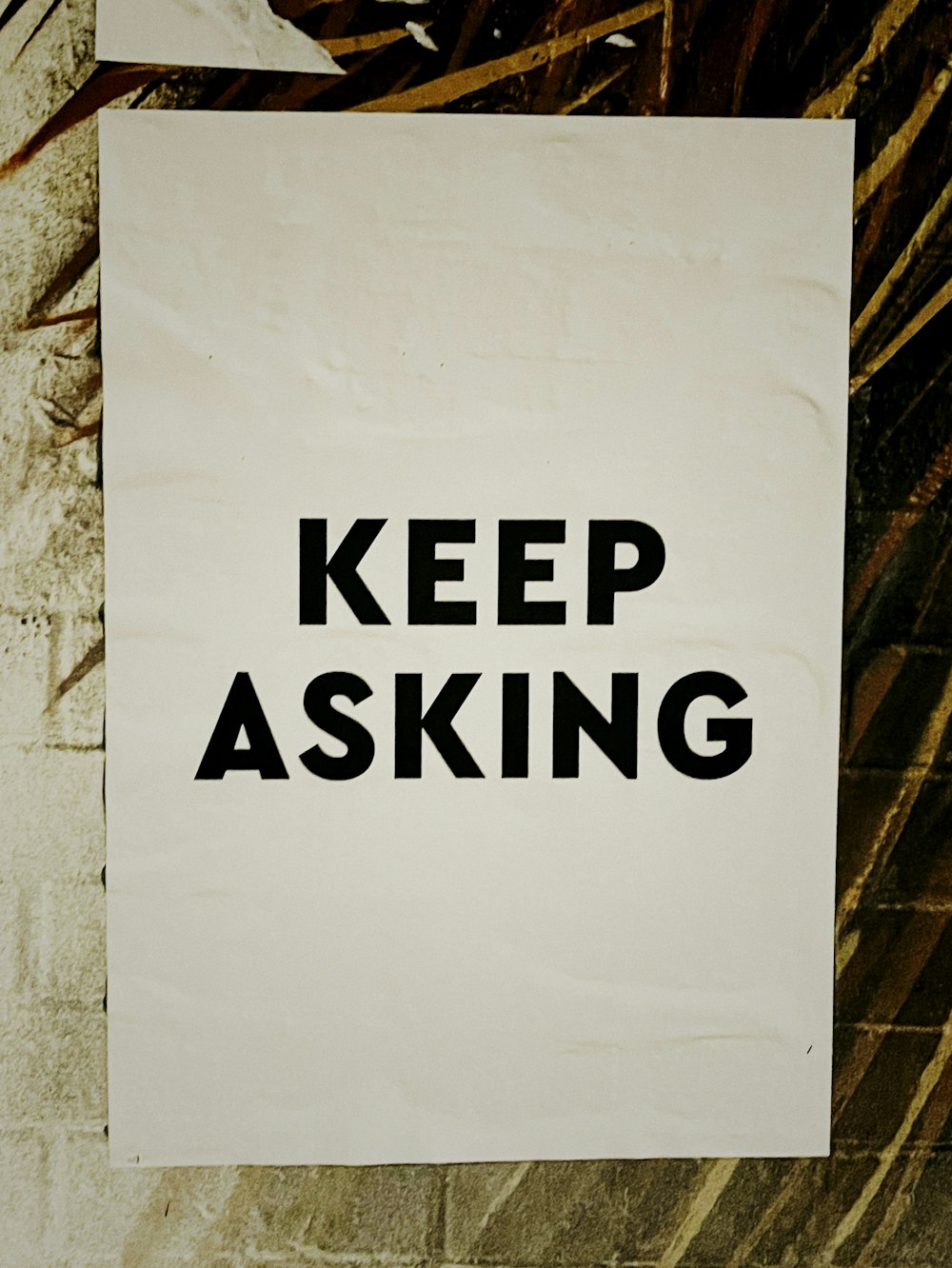 a sign that says keep asking on a wall
