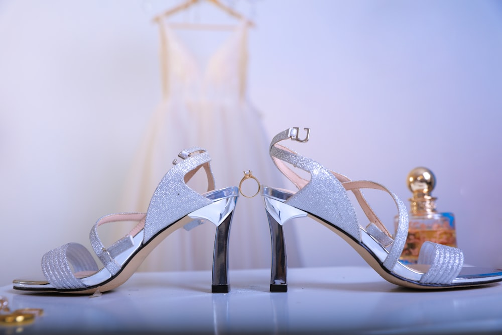 a pair of silver high heeled shoes sitting on top of a table