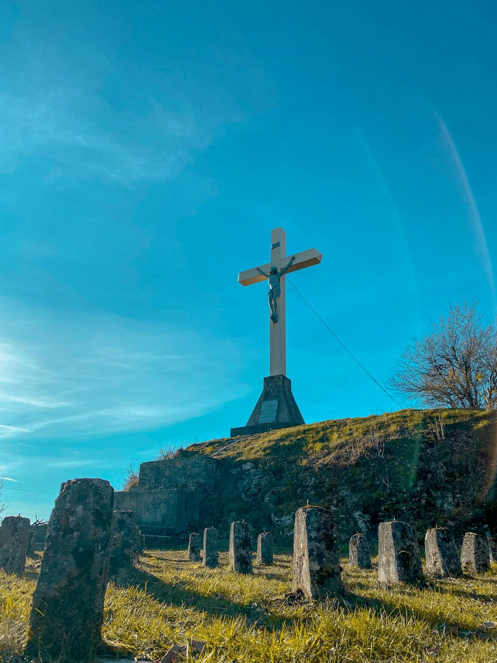 a cross on top of a hill in a cemetery