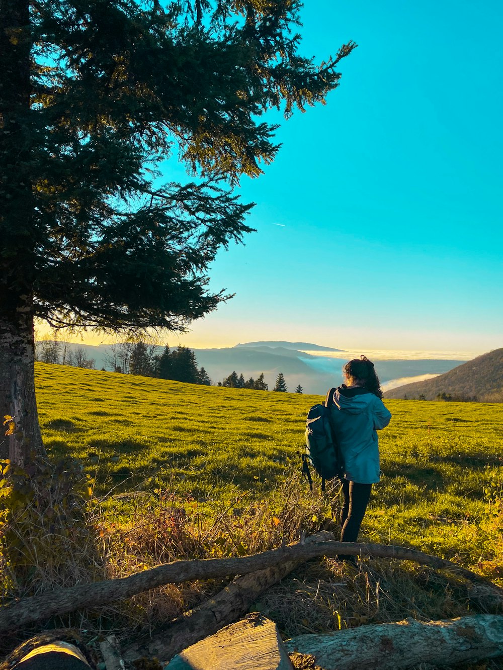 a woman standing in a field with a backpack