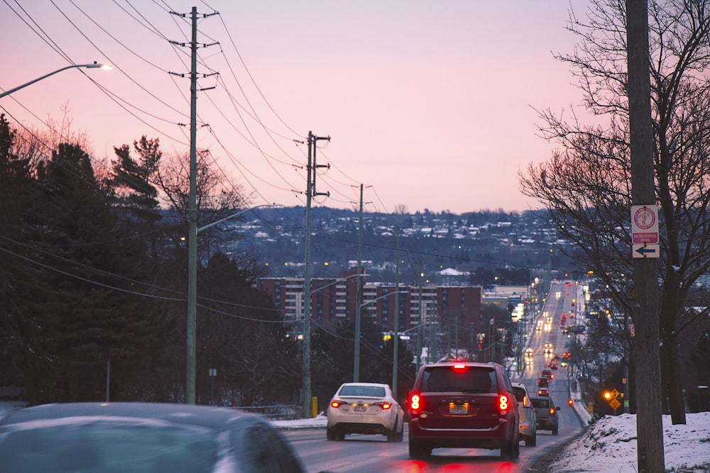 a city street with cars driving down it at dusk