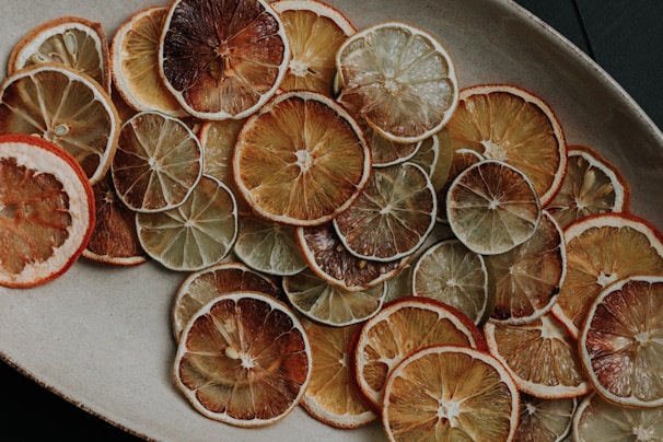 Close-up of vibrant dried lemon slices arranged artistically on a white background.