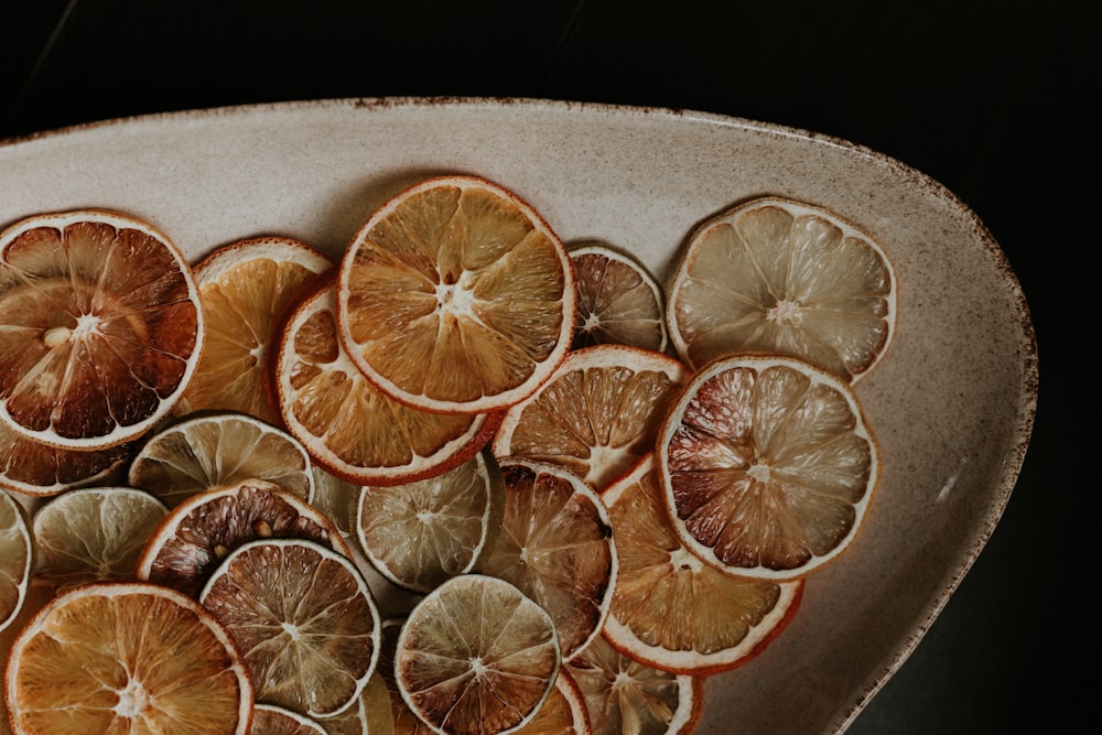 a white bowl filled with sliced oranges on top of a table