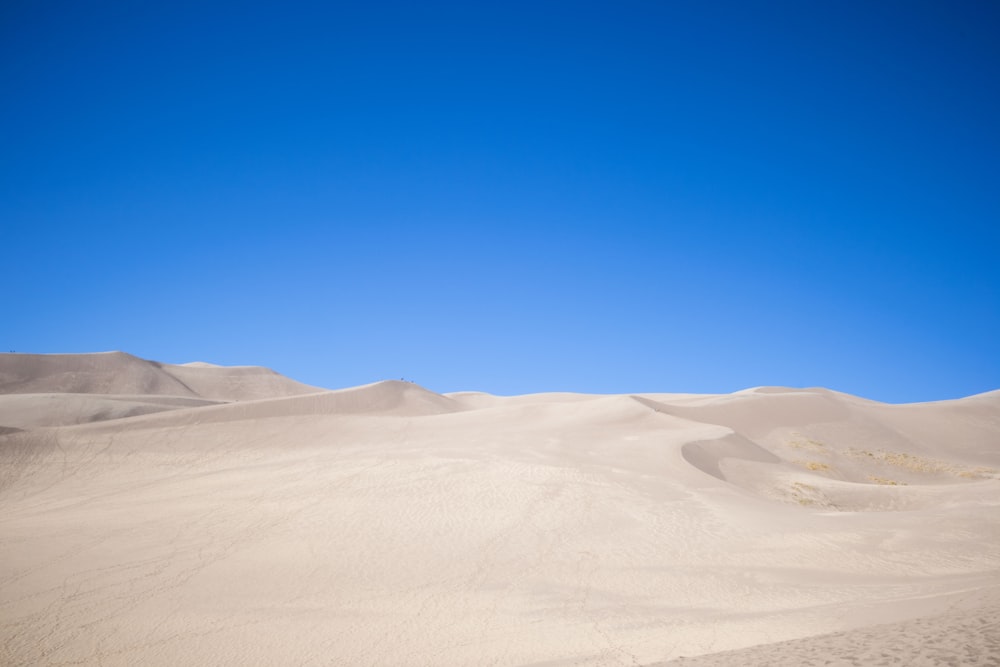 a person riding a snowboard on top of a sandy hill