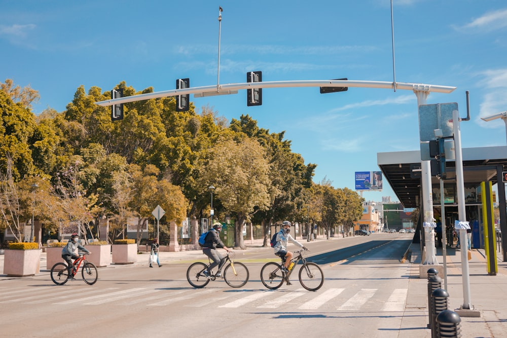 um grupo de pessoas andando de bicicleta do outro lado de uma rua