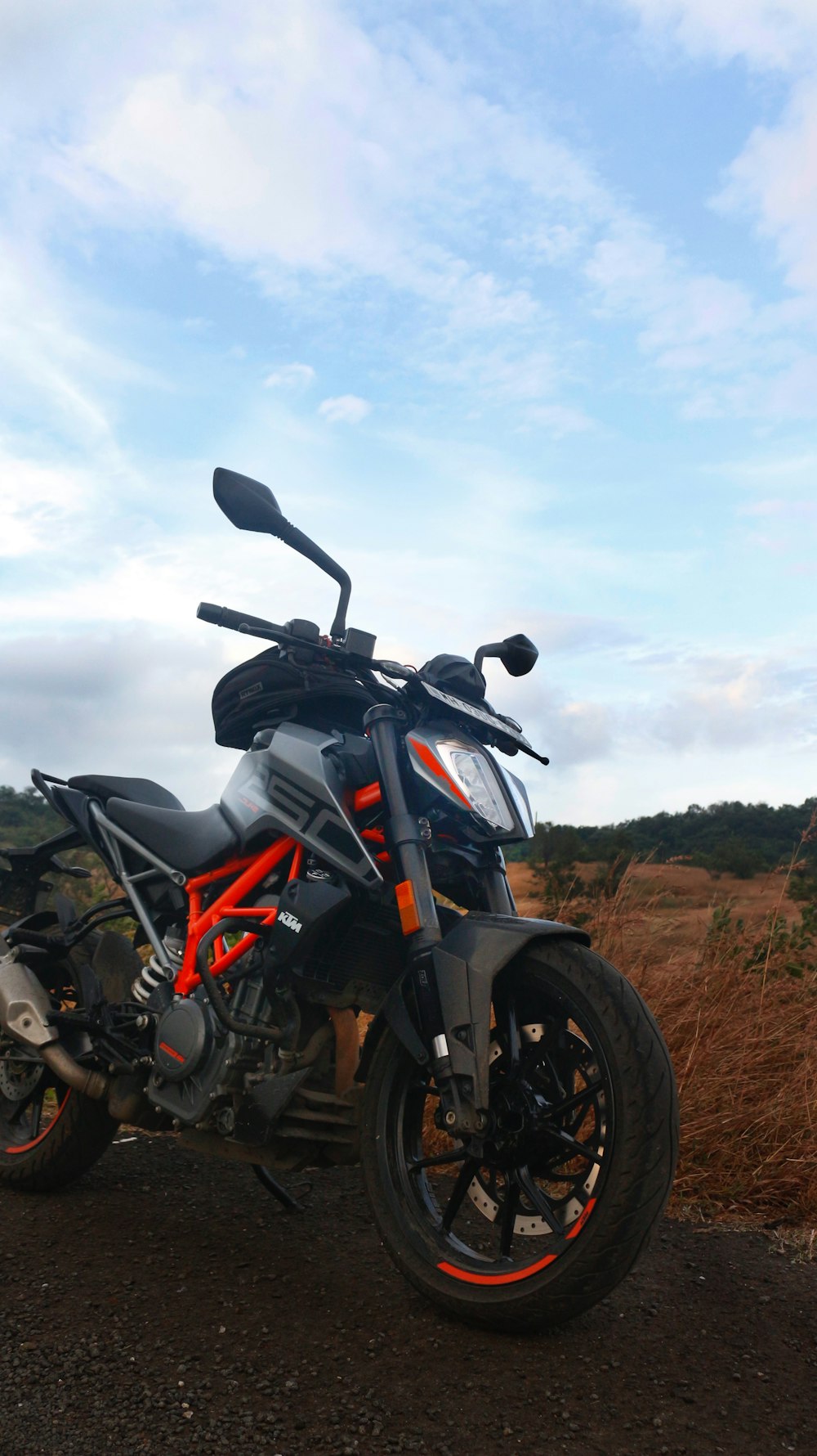 a motorcycle parked on the side of a dirt road