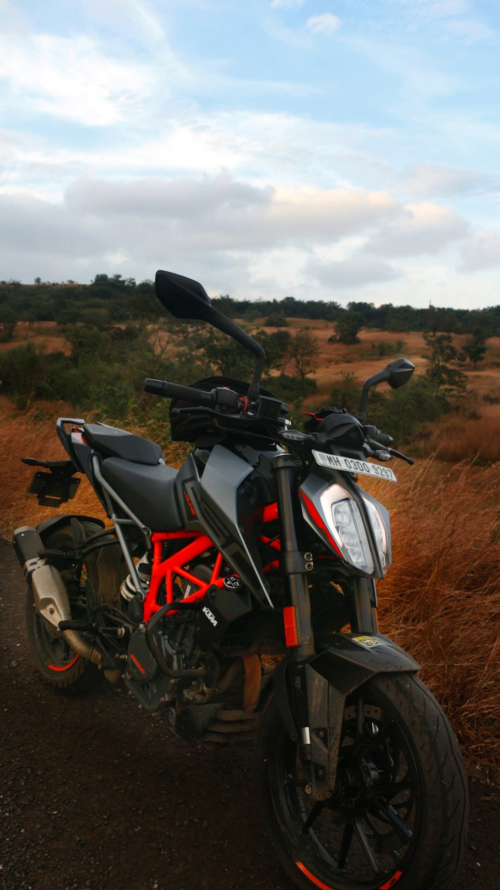 a motorcycle parked on the side of a dirt road