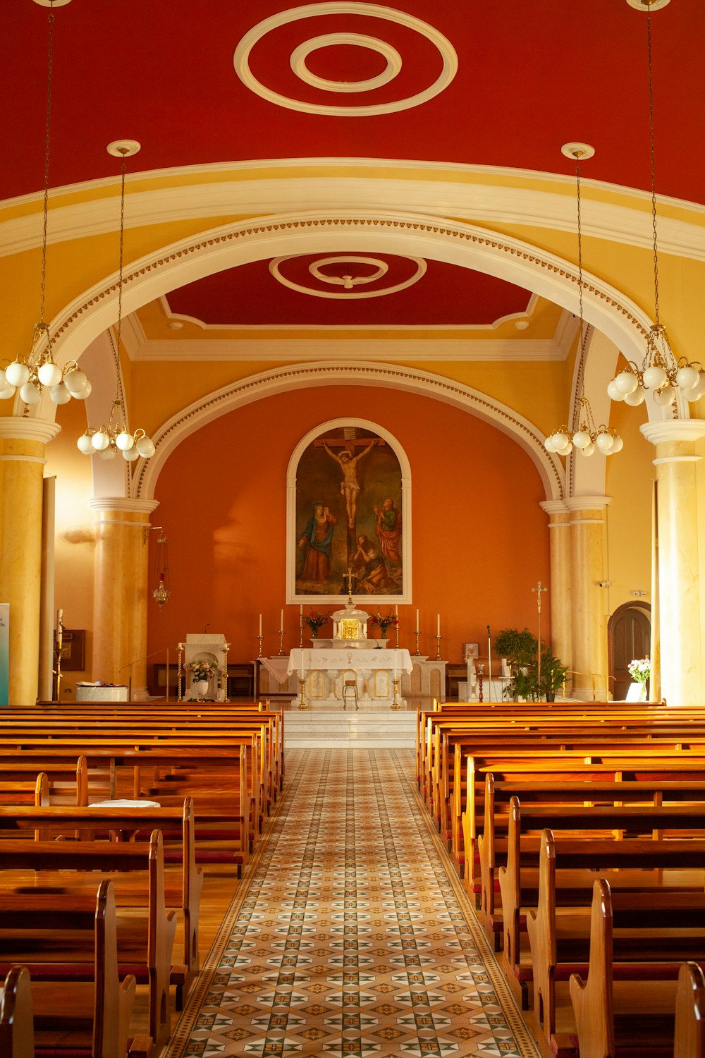 a church with a red and yellow ceiling and pews