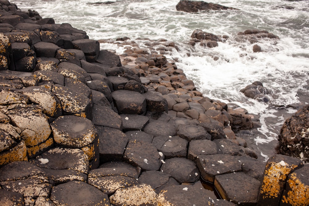 a rocky shore with waves crashing in to shore