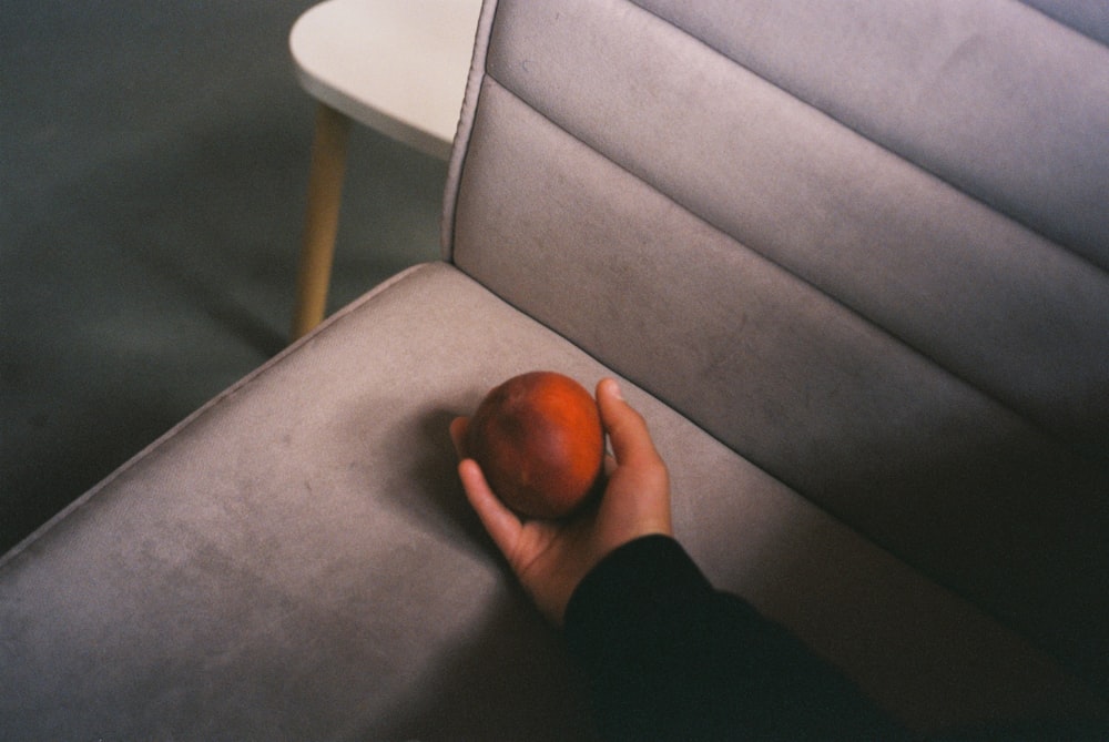 a person is holding an apple on a couch