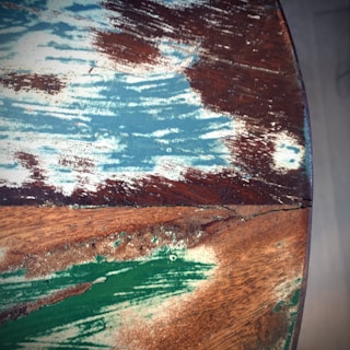 A layered wood art piece showcasing a scenic landscape with vibrant colors and textures.