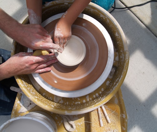 a group of people working on a pottery wheel