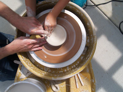 a group of people working on a pottery wheel
