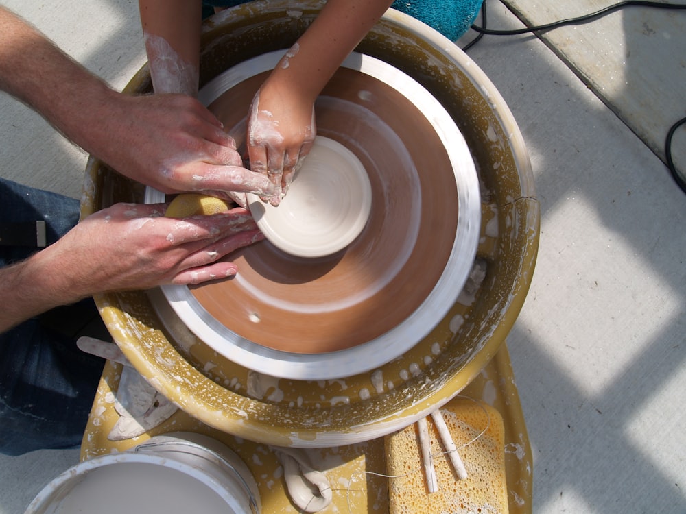 Un grupo de personas trabajando en una rueda de cerámica