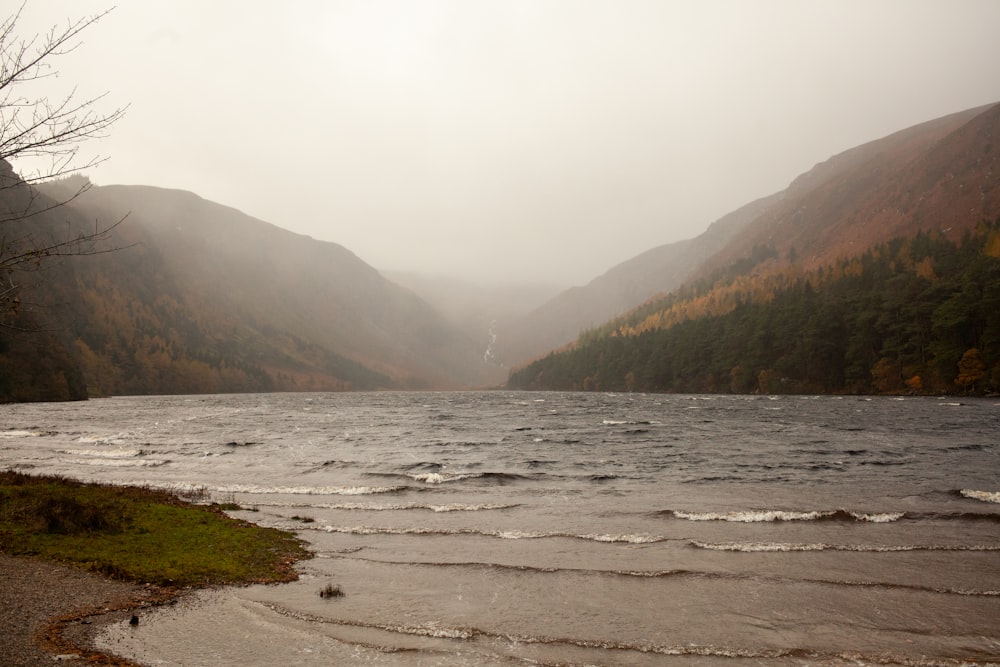 a body of water surrounded by mountains and trees