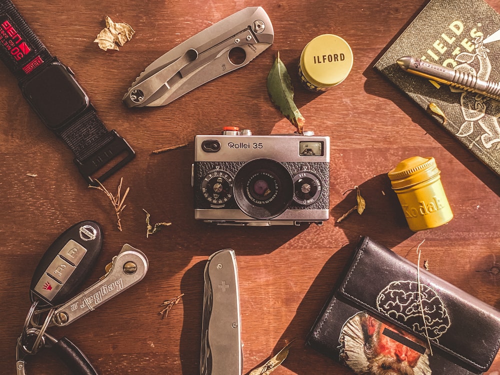 a wooden table topped with a camera and other items