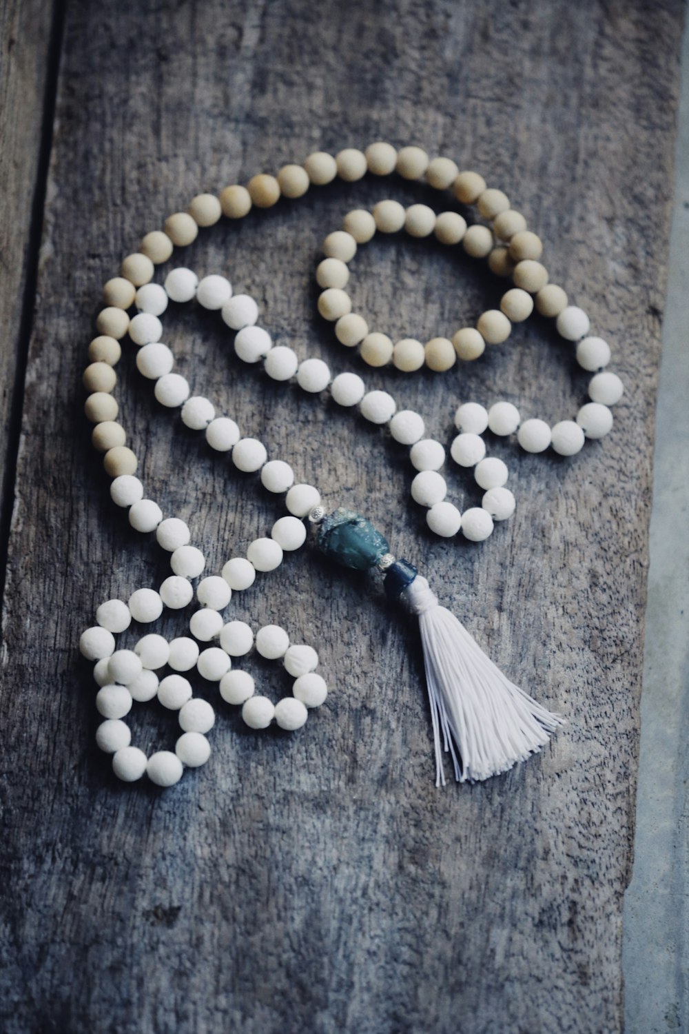 a rosary with white beads and a tassel
