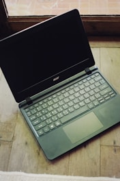 a laptop computer sitting on top of a wooden table