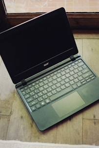 a laptop computer sitting on top of a wooden table