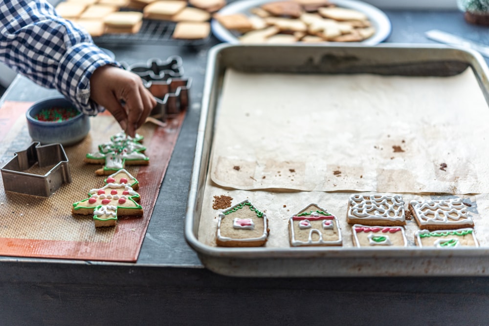 a person decorating cookies on a table