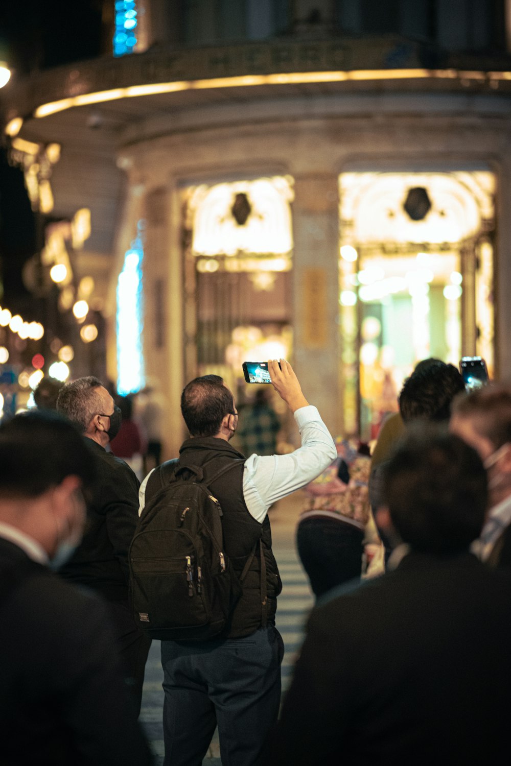 a man taking a picture of a building with a cell phone