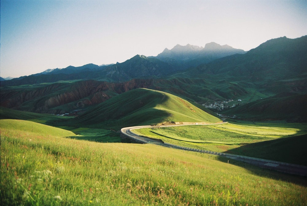 a scenic view of a winding road in the mountains