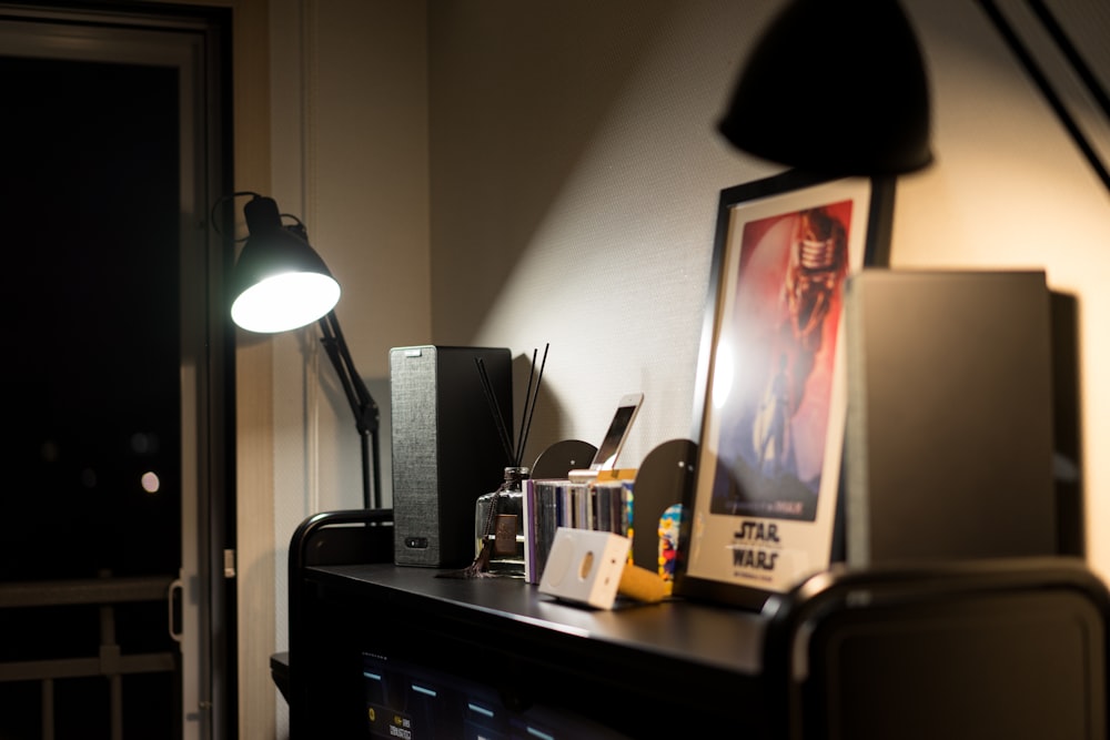 ein Schreibtisch mit einer Lampe und einem Bild darauf