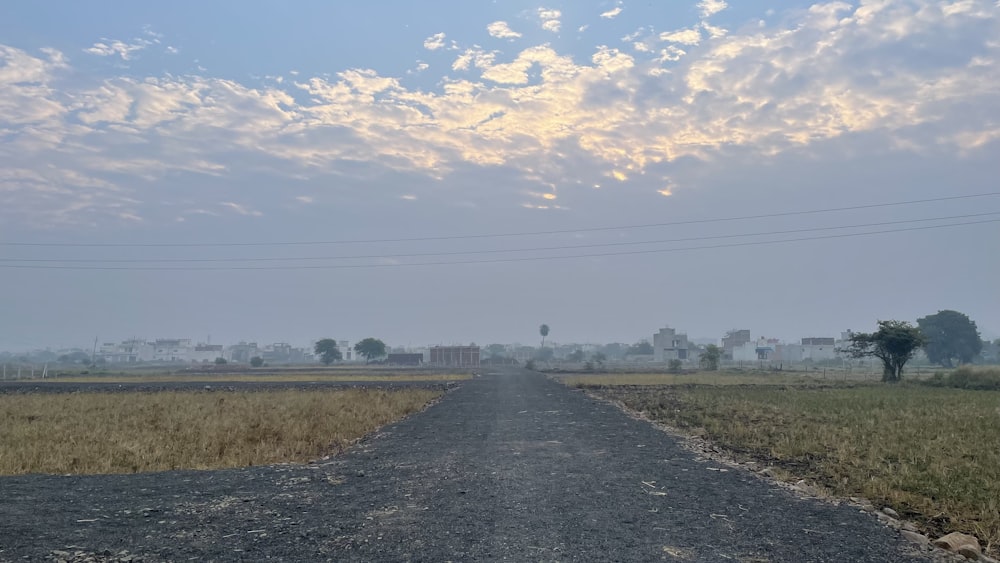 an empty road in the middle of a field