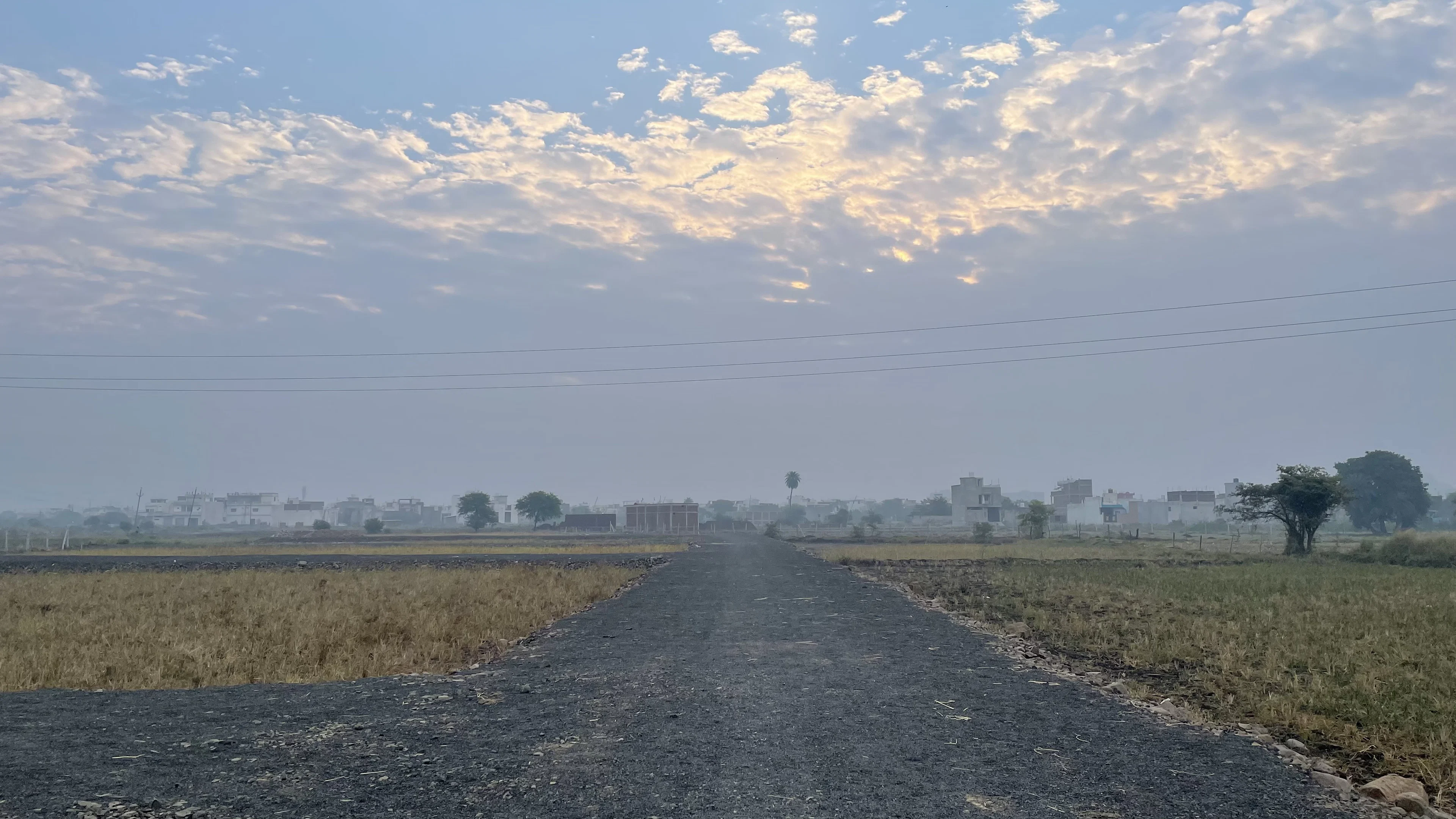 Straight road running between level open fields