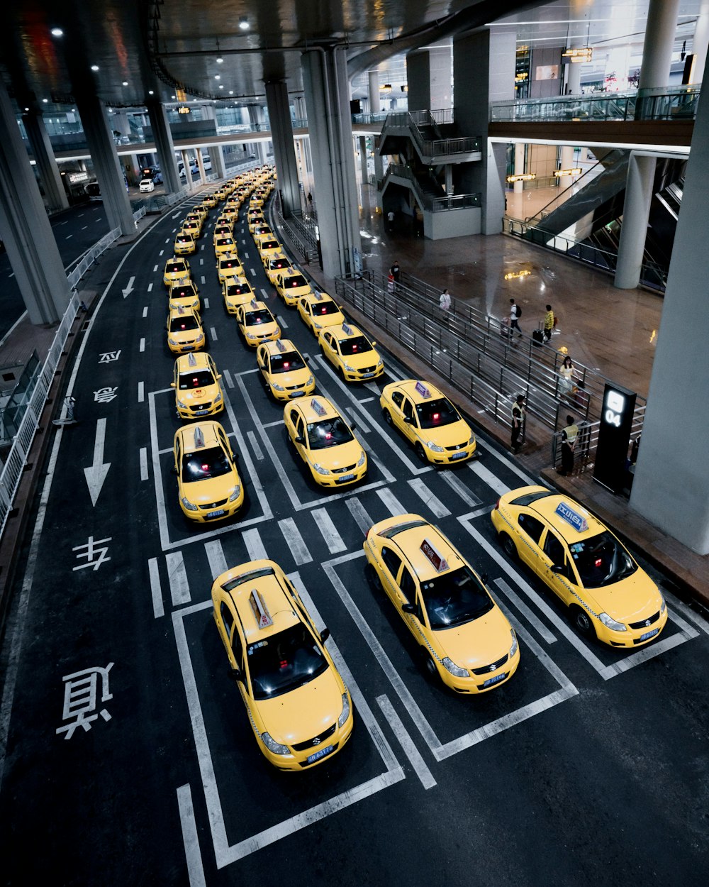a line of taxi cabs parked in a parking garage