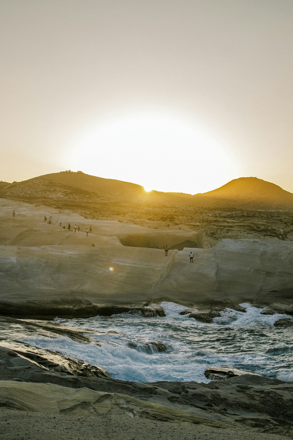 a group of people standing on top of a sandy beach