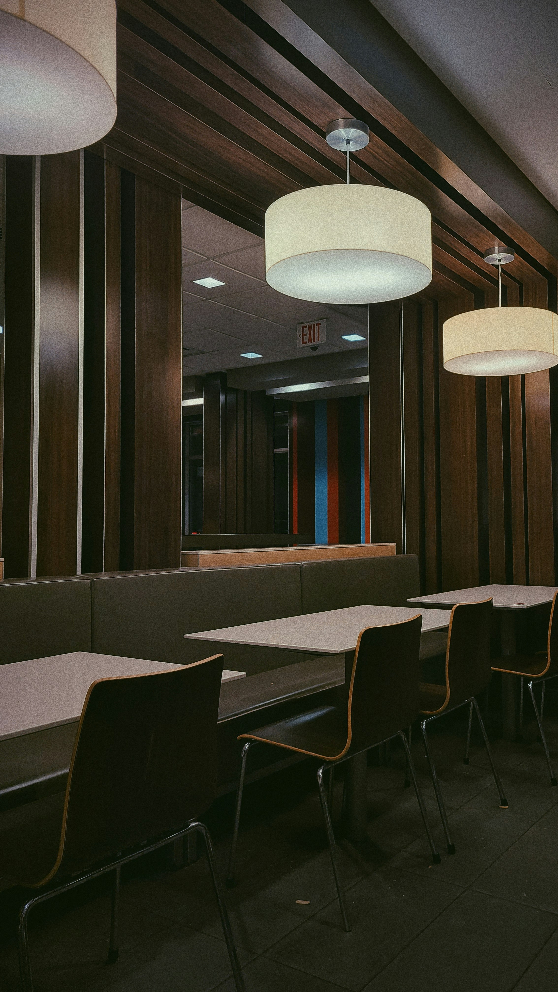 a restaurant with tables, chairs, and lamps