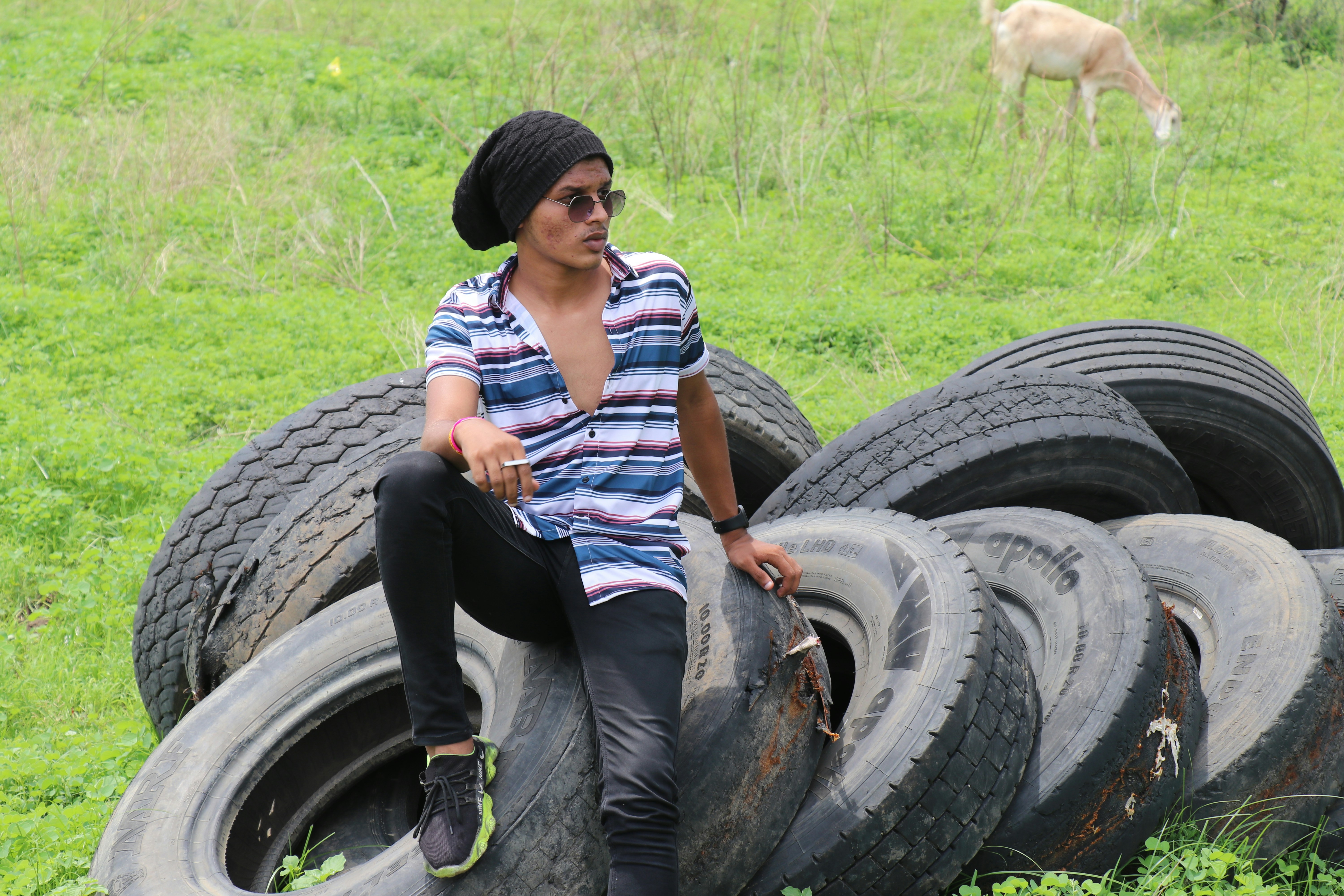 a man sitting on top of a pile of tires