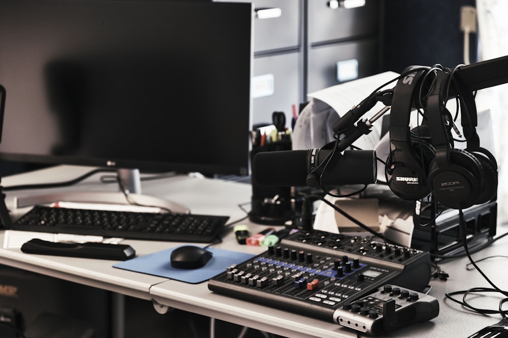 a computer desk with a microphone and headphones on it