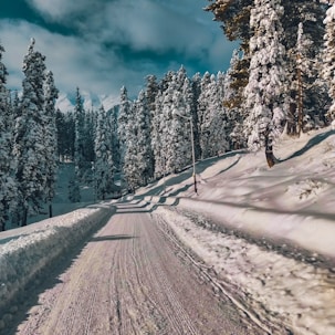 a person riding a snowboard down a snow covered road